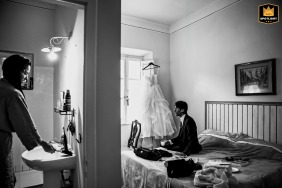   In Castiglioncello, Livorno, Italy, a candid black and white shot reveals an authentic preparation moment between the bride and groom before the celebration.